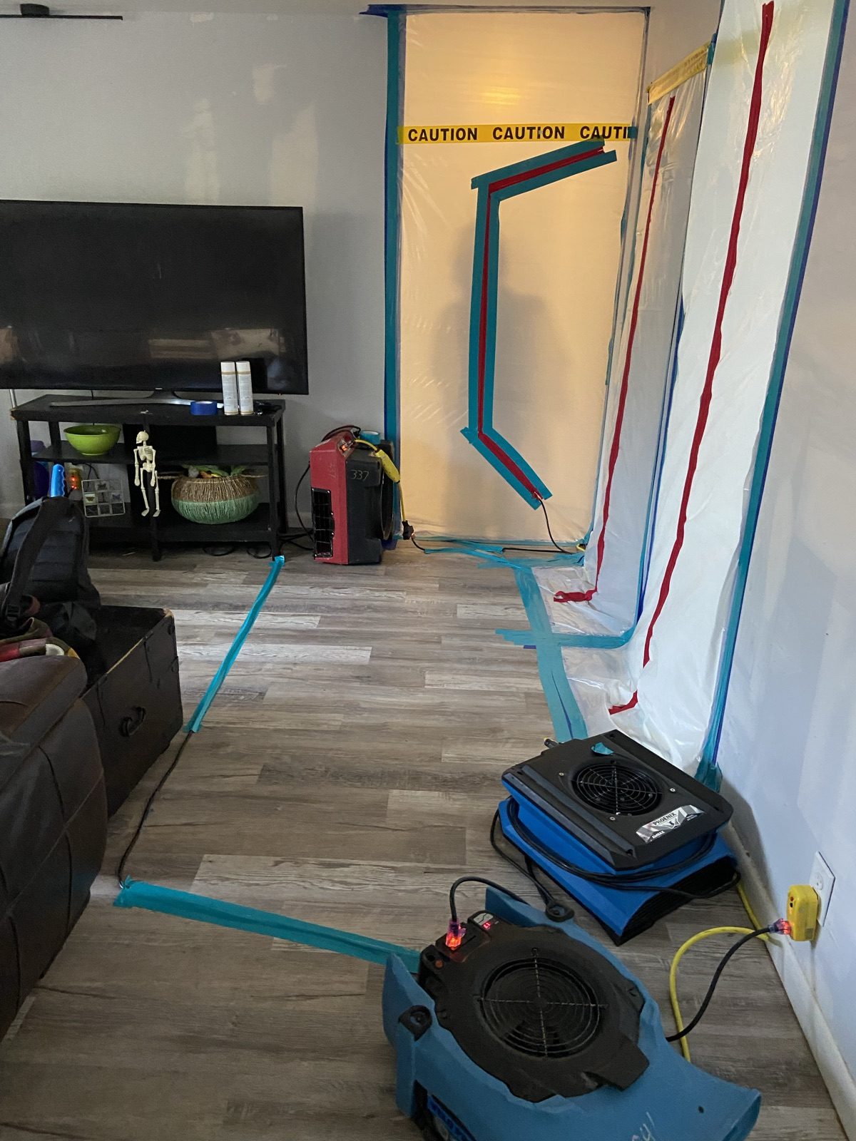 Disaster Recovery Experts air movers and dehumidifier drying a water-damaged room under containment