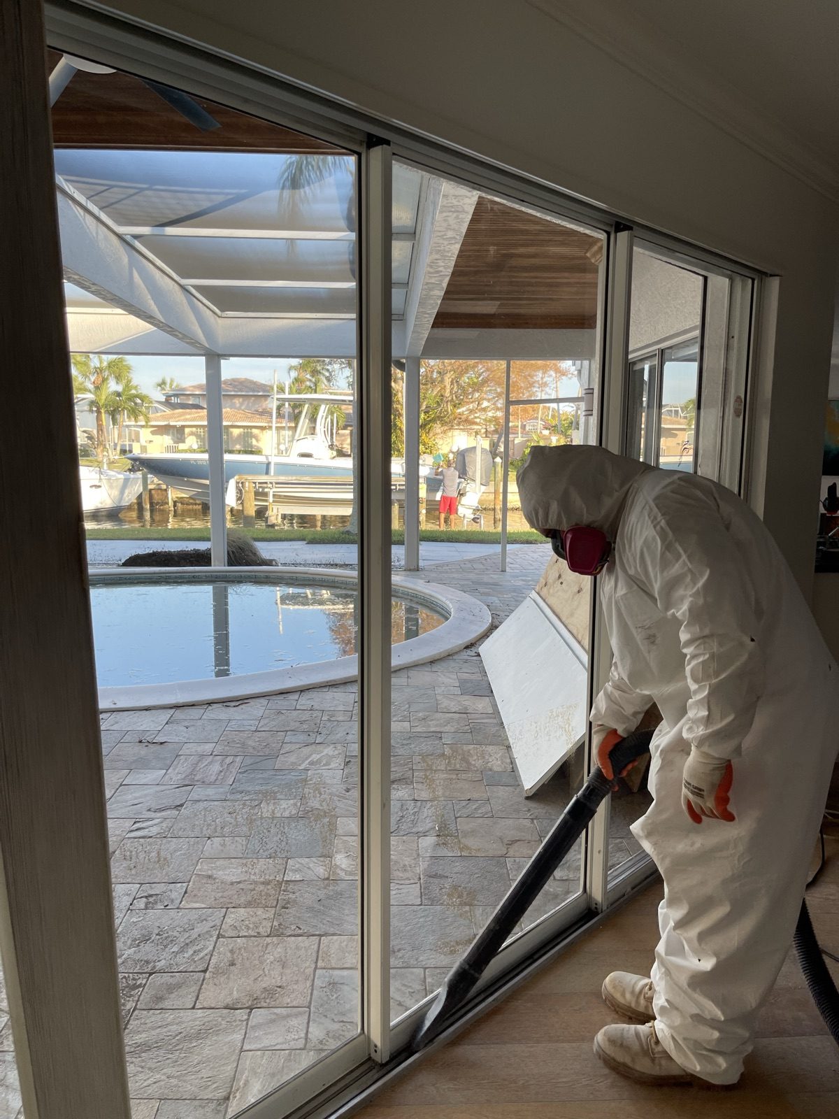 Technician in PPE performing water extraction at a waterfront property