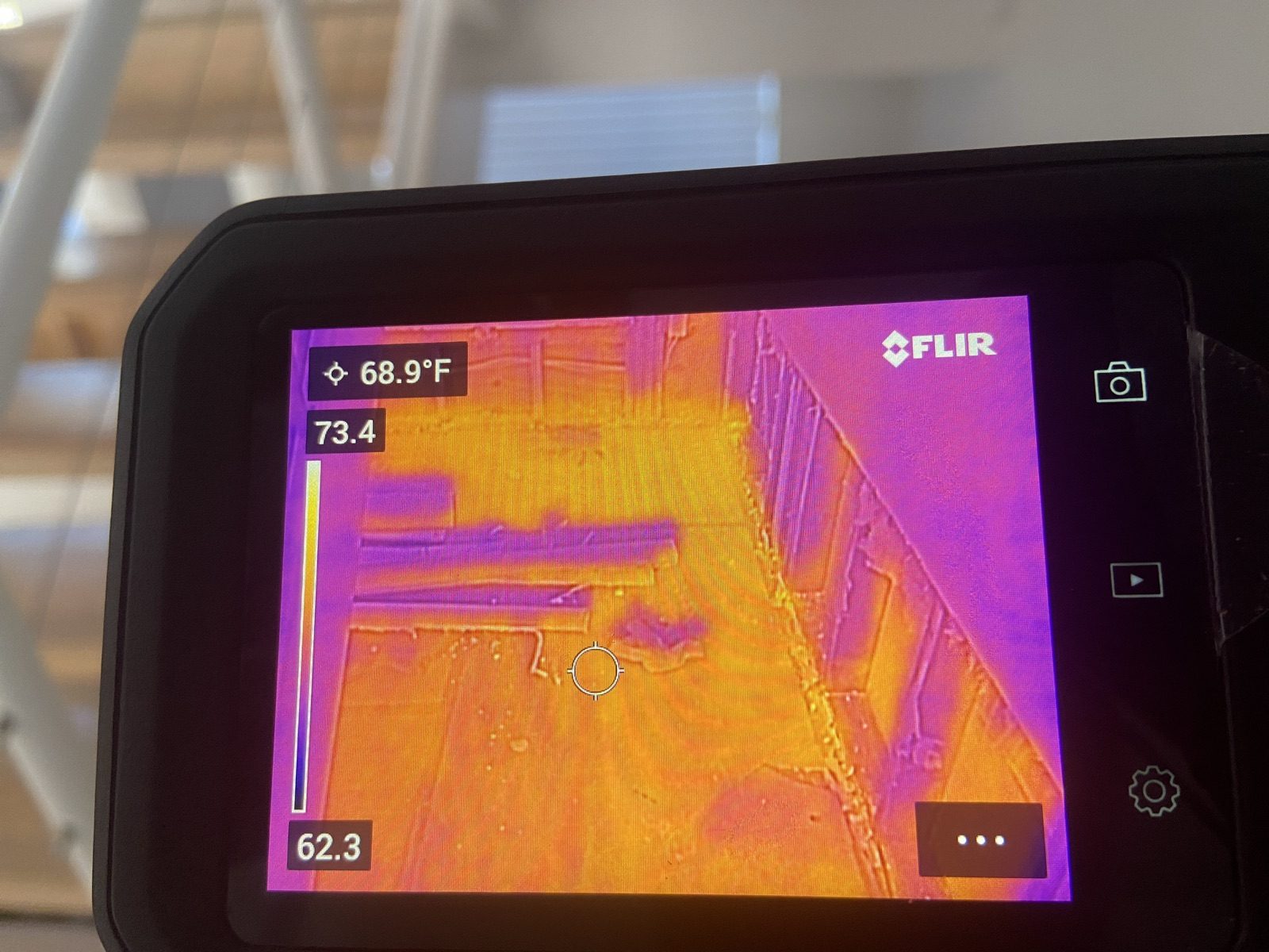 FLIR thermal imaging camera detecting hidden moisture behind surfaces